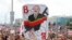 Минскиде митингчилердин бири кармап чыккан Лукашенконун шакаба сүрөтү.