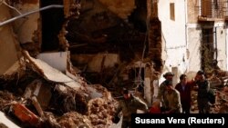 Куткаруучулар суу ташкындан жабыркагандарды жетелеп баратышат. Летур шаары. Испания. 30-октябрь, 2024-жыл.