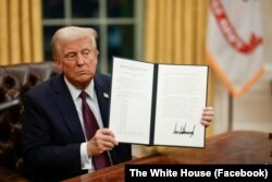 Дональд Трамп показує підписаний ним указ у перші години перебування на посаді президента США