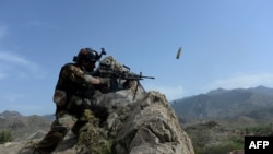 An Afghan soldier fires during an ongoing an operation against Islamic State (IS) militants in the Achin district of Nangarhar Province on April 11.