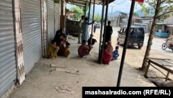 په لوی ماموندو کې د عملیاتو له وجې د بې ځایه شوې کورنۍ غړي د سړک پر غاړه ګاډي ته انتظار باسي - د جولای ۳۰مې انځور.