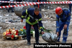 Рятувальники несуть частину російської крилатої ракети «Іскандер-К», яка влучила в житловий будинок у Києві 31 липня 2025 року