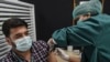 کراچۍ کې یوه ډاکټره یوه کس ته د کوویډ-۱۹ واکسین لګوي - انځور له ارشیفه