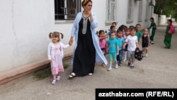 Türkmenistandaky çagalar baglarynyň birinde terbiýeçi zenan we çagalar