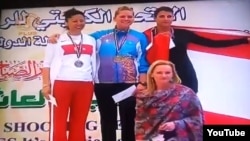 Maria Dmitrenko (top center) stands atop the podium following her first-place finish at the Grand Prix shooting championship in Kuwait.