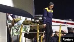 Un pasager rănit în accidentul cursei Azerbaijan Airlines de lângă orașul kazah Aqtau este transportat pe o targă către o ambulanță, odată cu sosirea în capitala azeră Baku, 26 decembrie.