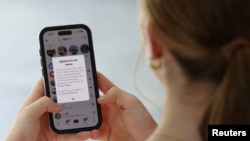 O adolescentă din Australia citește un mesaj de actualizarea a termenelor și condițiilor de la TikTok. 