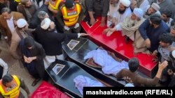 په بنو کې خلک پر چاوڼۍ په ځانمرګو بریدونو کې د وژل شویو ملکیانو د جنازې تیاری کوي - د مارچ پینځمې انځور.