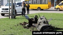 Українські силовики біля фрагмента ракети «Точка-У» після ракетного удару російськими військами по залізничному вокзалі в Краматорську, 8 квітня 2022 року