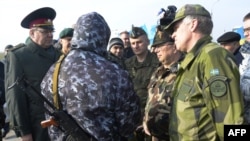 Observatorii militari OSCE încercînd să negocieze cu un militar pro-rus