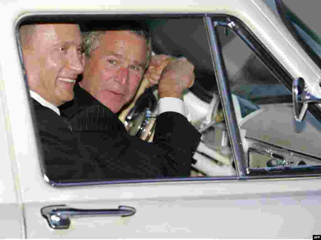 Președintele american George W. Bush conduce mașina Volga 1956 a președintelui rus Vladimir Putin, în afara Moscovei, în mai 2005.