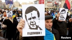 Protesters hold portraits of Ukrainian President Viktor Yanukovych during a demonstration in support of EU integration on Independence Square in Kyiv on November 29.
