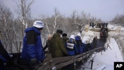 Спостерігачі ОБСЄ йдуть зруйнованим мостом у Станиці-Луганській. 16 грудня 2016 року