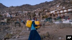 کودکی در شهر کابل در حال انتقال آب 