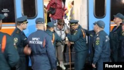 Workers from the Russian Emergencies Ministry in Oryol assist residents of the Kursk region who were evacuated following an incursion by Ukrainian troops.
