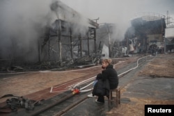 A vendor sits at the site of the Barabashovo market hit by a Russian drone strike in Kharkiv, Ukraine, on May 6.
