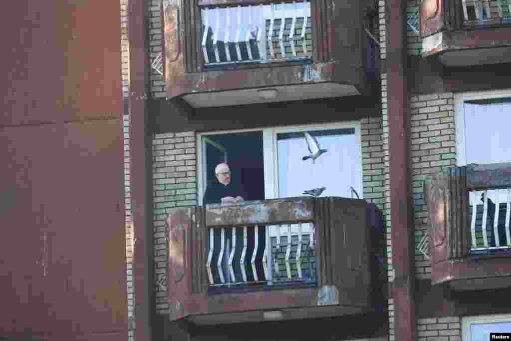 Muškarac u Domu penzionera hrani golubove, u neoštećenom dijelu zgrade nakon požara u Domu penzionera u Tuzli, Bosna i Hercegovina, 5. novembra 2025.