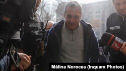პოლიციას კალინ ჯორჯესკუ (ცენტრში) პროკურატურაში მიჰყავს. ბუქარესტი, 26 თებერვალი, 2025.
