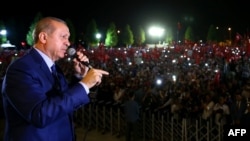 Turkish President Recep Tayyip Erdogan addresses people gathered at the Presidential Complex to protest the July 15th failed military coup attempt in Ankara, on August 10.