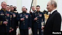 Президент России Владимир Путин с награжденными медалью "Золотая Звезда" и получившими звания "Героев России" за участие в войне против Украины офицерами Минобороны и Росгвардии в День защитника Отечества в Кремле. Москва, 23 февраля 2025 года