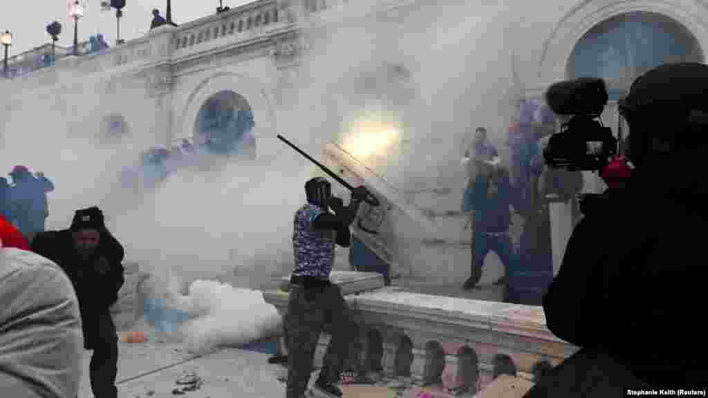 Полиция применяет слезоточивый газ, чтобы разогнать толпу радикальных сторонников Трампа у здания Капитолия.