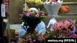 Алматының Тастақ базарында гүл сатып тұрған адам. 2025 жылдың шілде айы.