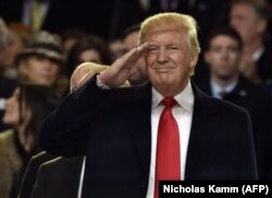 Президент США Дональд Трамп салютує під час президентського інавгураційного параду 20 січня 2017 року у Вашингтоні