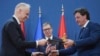 Președintele sârb Aleksandar Vucic (centru) urmărește cum miniștrii Apărării maghiar (b) și sârb fac schimb de documentul acordului de cooperare militară dintre cele două țări. 1 aprilie 2025