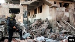 Египеттин коопсуздук кызматтары Мансурадагы полициякананын сыртандагы жардыруу болгон жерди текшеришүүдө. 24-декабрь  2013