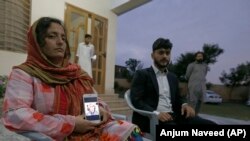Kaneez Sughra, wife of prominent Pakistani journalist Matiullah Jan, shows a picture her husband to journalists.