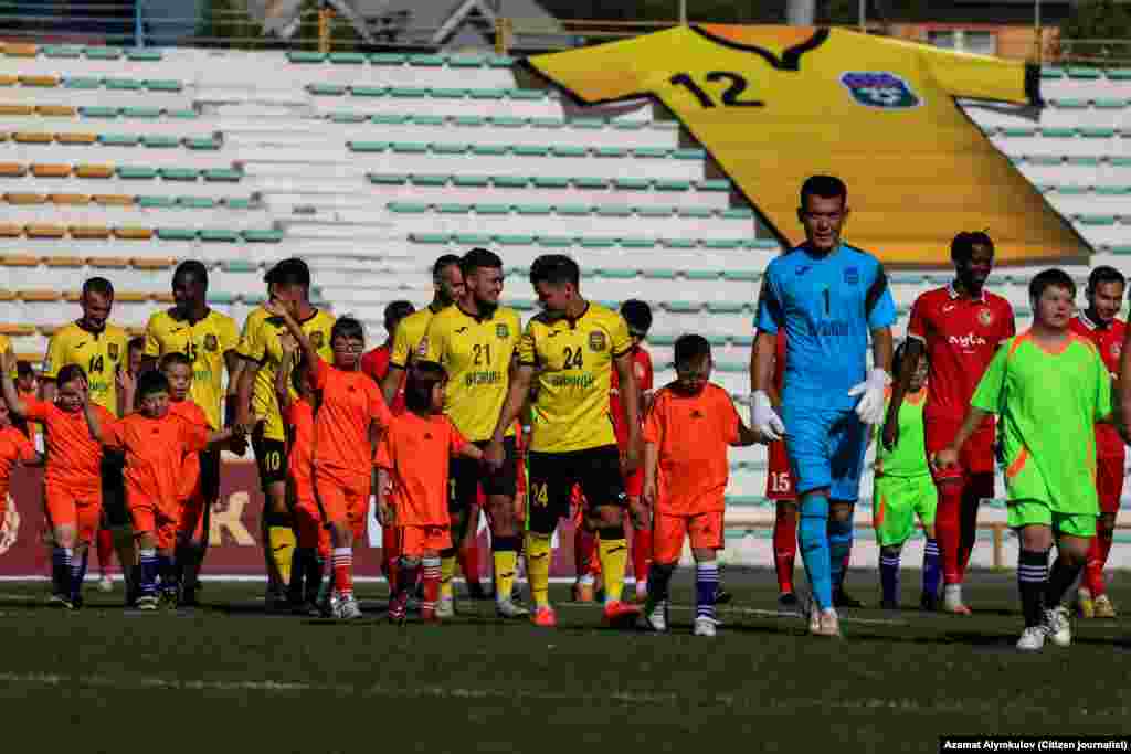 Футболчулар беттештин алдында оюн талаасына "Күн балдары" менен чыгып келаткан учур.