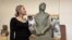 Dorina Roșca pozând alături de monumentul femeii migrante. 