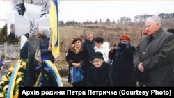Відкриття надмогильного пам’ятника Михайла Петричкові у вигляді козацького хреста 15 березня 2012 року. Дружина Катерина присіла на лавиці