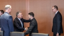 Emisarul special al SUA, Steve Witkoff, și președintele ucrainean Volodimi Zelenski se salută la Berlin, pe 14 decembrie. Gazda întâlnirii, cancelarul german Friedrich Merz, se află în spatele lui Zelenski.