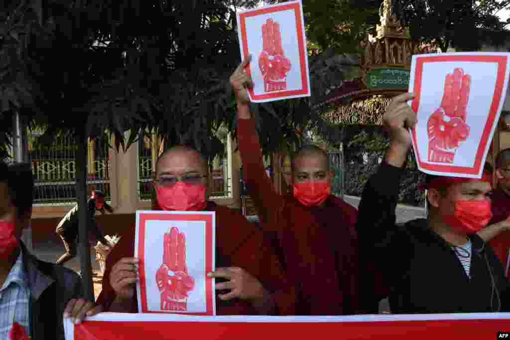 У місті Мандалаї до акцій протесту долучилися буддійські монахи, вони тримають у руках плакати із зображенням жесту-символу опору військовому перевороті в М'янмі