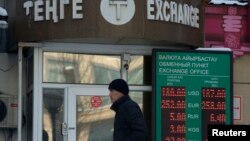 Ақша айырбастау орны алдынан өтіп бара жатқан адам. Алматы, 11 ақпан 2014 жыл.
