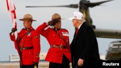 Un ofițer al Poliției Regale Călare a Canadei salutând, în momentul în care președintele american, Donald Trump, coboară din avion la sosirea sa în Canada, pe 15 iunie, înainte de întâlnirea liderilor G7 la Kananaskis