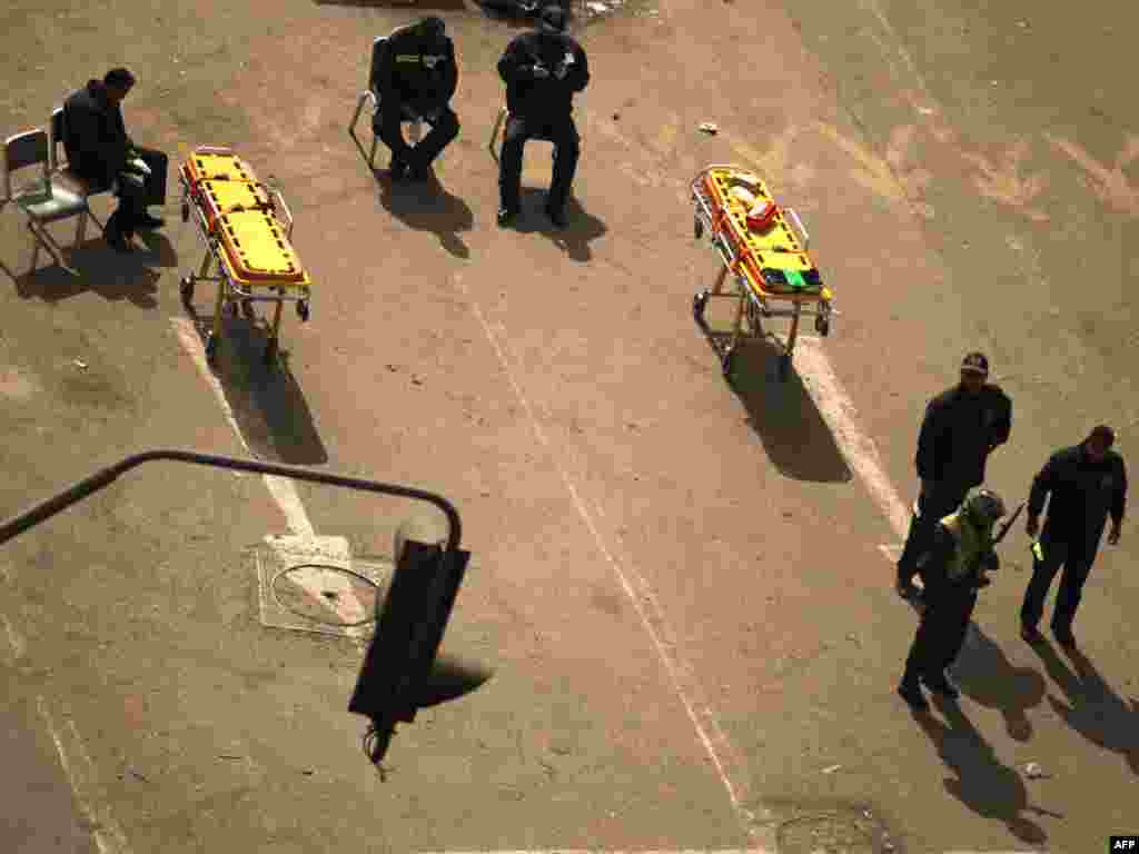 A soldier stands guard next to stretchers and paramedics as antigovernment protesters gather on Tahrir Square.