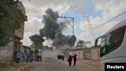 Oamenii fug în timp ce se ridică coloane de fum în urma unui atac aerian israelian în Deir al-Balah, Fâșia Gaza, 21 august 2025. Captură de ecran dintr-un videoclip obținut de Reuters.