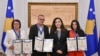 Tre të mbijetuarit e dhunës seksuale gjatë luftës në Kosovë, Shyrete Tahirit (e para majtas), Ramadan Nishori pranë presidentes Vjosa Osmani dhe Vasfije Krasniqit (e para djathtas), pranojnë medalje nderi, 18 prill, Prishtinë.
