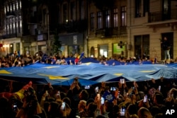 Imagine de duminică noapte, din București. Susținătorii lui Nicușor Dan sărbătoresc câștigarea alegerilor.