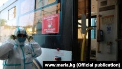 Коомдук транспортту дезинфекциялап жаткан кызматкер. Бишкек. Июль, 2021-жыл.