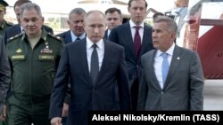 На переднем плане: министр обороны России Сергей Шойгу, президент России Владимир Путин и президент Татарстана Рустам Минниханов во время посещения Казанского авиационного завода имени С. П. Горбунова — филиала ПAO «Туполев». Татарстан, Казань, май 2019 года 
