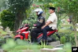 پرابوو سوبیانتو پشت موتورسیکلت یک افسر پلیس، فوریه ۲۰۲۴