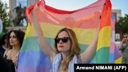 پرچم رنگین‌کمانی در دست یکی از حامیان جامعهٔ دگرباشان